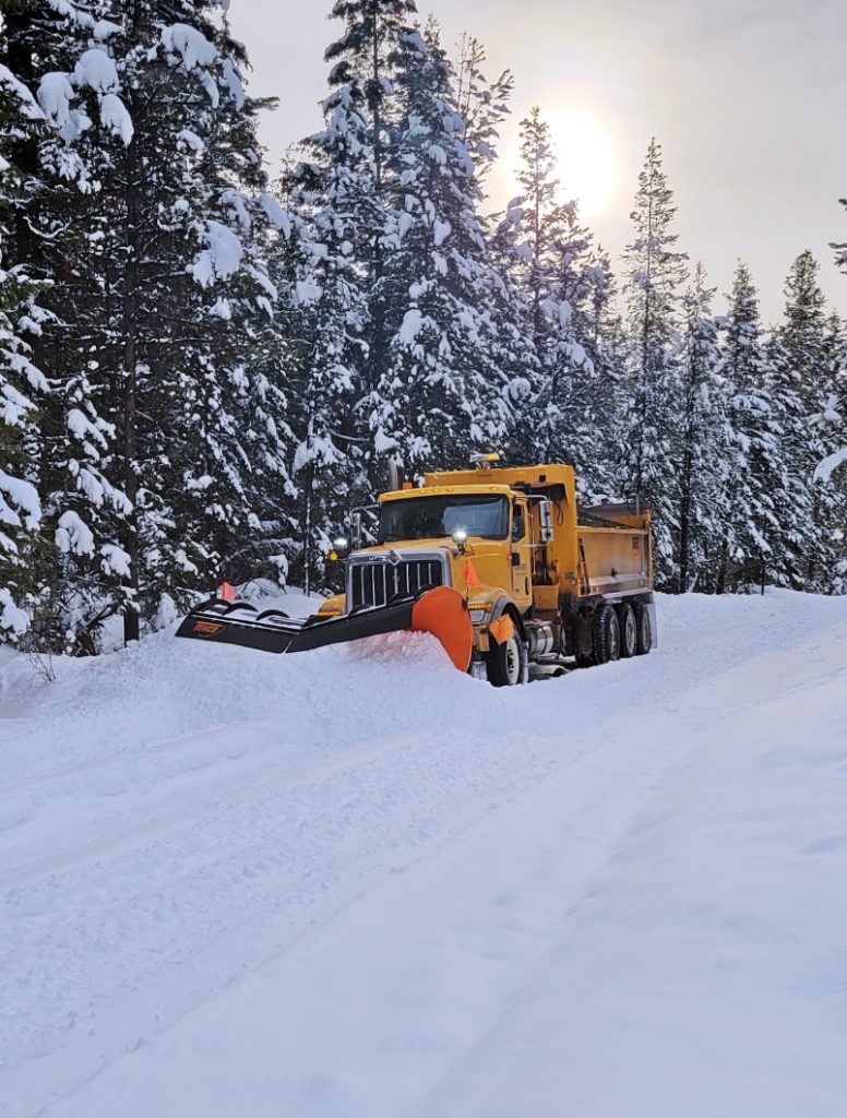 A Dawson Road Maintenance snowplow clearing deep snow near Helena Lake in British Columbia.
